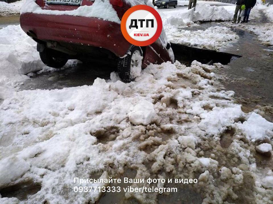 В Киеве прорвало трубу и затопило улицу Ольжича. У места прорыва припаркованный автомобиль наполовину провалился под землю. 