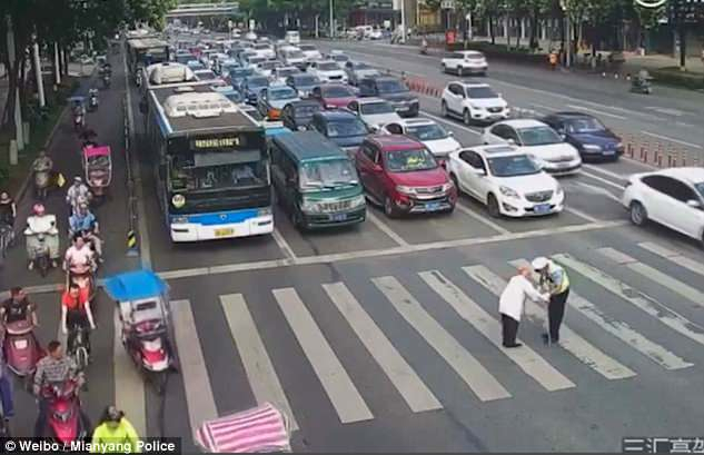 В Китае полицейский помог пожилому человеку пересечь перекресток, перенеся его на своей спине. 