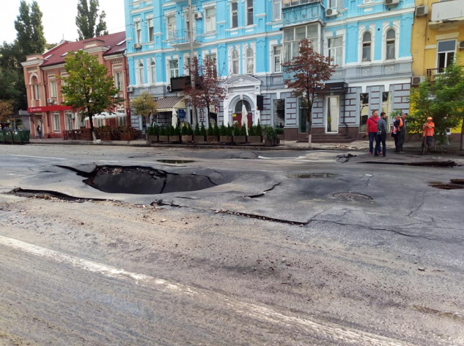 В центре Киева на улице Антоновича после большого ливня прямо посреди дороги провалился асфальт на проезжей части. 